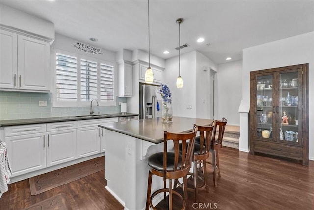 12473 Constellation St, Eastvale, CA 91752 - kitchen with a sink, stainless steel refrigerator with ice dispenser, dark wood finished floors, a center island, and a breakfast bar area