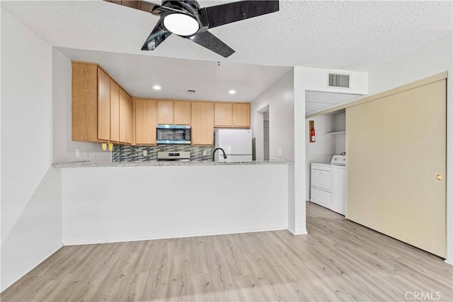 105 Tangelo Unit 400, Irvine, CA 92618 - kitchen with appliances with stainless steel finishes, light wood-style floors, independent washer and dryer, ceiling fan, and tasteful backsplash