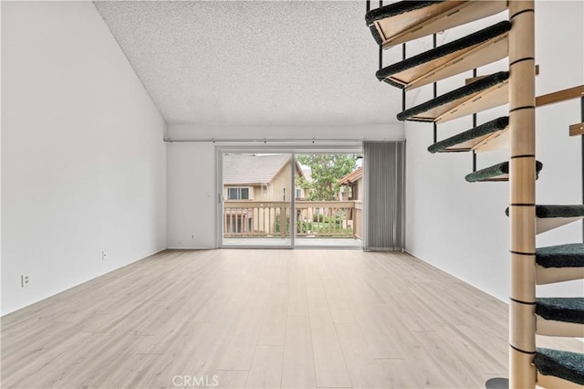105 Tangelo Unit 400, Irvine, CA 92618 - unfurnished living room with a textured ceiling, wood finished floors, and stairway