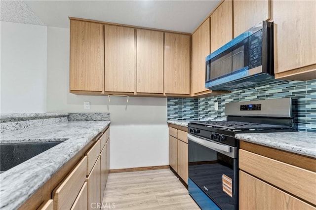 105 Tangelo Unit 400, Irvine, CA 92618 - kitchen featuring appliances with stainless steel finishes, light brown cabinetry, tasteful backsplash, light stone counters, and light wood finished floors