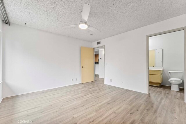 105 Tangelo Unit 400, Irvine, CA 92618 - unfurnished bedroom with light wood-style flooring, a textured ceiling, ensuite bathroom, and a ceiling fan
