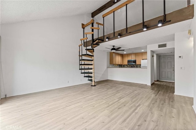 105 Tangelo Unit 400, Irvine, CA 92618 - unfurnished living room featuring stairway, light wood finished floors, ceiling fan, high vaulted ceiling, and a textured ceiling
