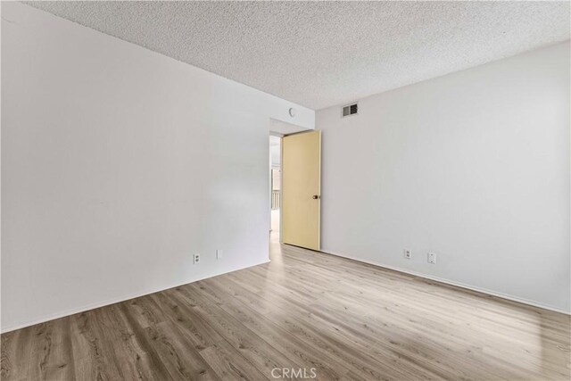 105 Tangelo Unit 400, Irvine, CA 92618 - empty room featuring wood finished floors and a textured ceiling