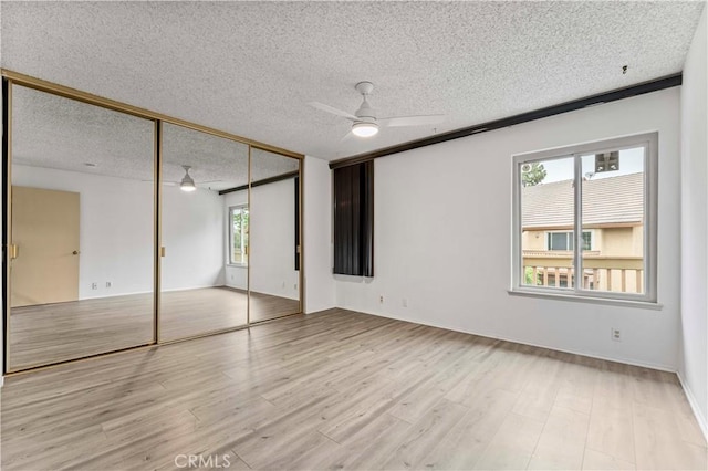 105 Tangelo Unit 400, Irvine, CA 92618 - unfurnished bedroom featuring a textured ceiling, a closet, wood finished floors, and ceiling fan