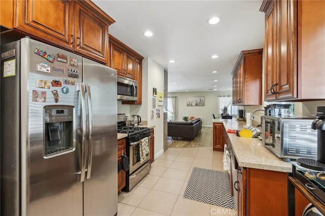 7117 Vanscoy Ave, North Hollywood, CA 91605 - kitchen featuring stainless steel appliances, light tile patterned floors, open floor plan, recessed lighting, and light stone countertops