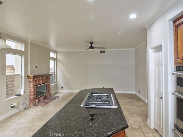 10655 Bruns Dr, Tustin, CA 92782 - living room featuring stone tile flooring, ornamental molding, ceiling fan, baseboards, and a fireplace