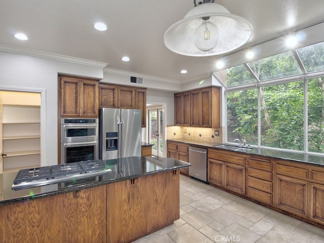 10655 Bruns Dr, Tustin, CA 92782 - kitchen featuring stainless steel appliances, a sink, ornamental molding, dark stone countertops, and backsplash