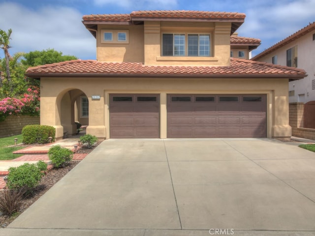 10655 Bruns Dr, Tustin, CA 92782 - mediterranean / spanish house with driveway, a garage, stucco siding, and a tiled roof