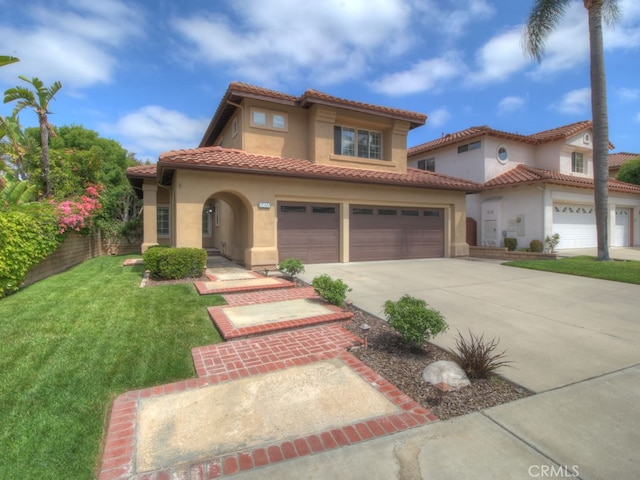 10655 Bruns Dr, Tustin, CA 92782 - mediterranean / spanish house featuring concrete driveway, stucco siding, a front lawn, a garage, and a tile roof