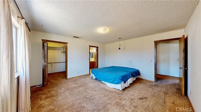20061 Seneca Rd, Apple Valley, CA 92307 - bedroom with carpet floors, a textured ceiling, a walk in closet, and ensuite bath