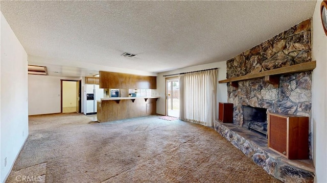 20061 Seneca Rd, Apple Valley, CA 92307 - unfurnished living room featuring a textured ceiling, light colored carpet, and a fireplace