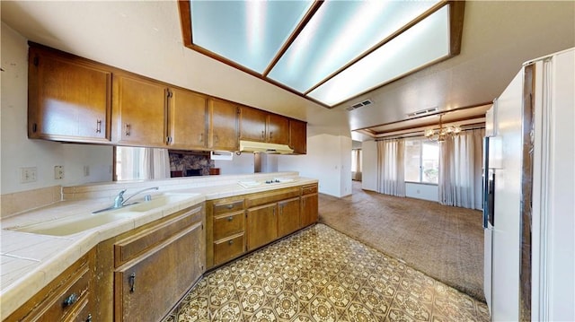 20061 Seneca Rd, Apple Valley, CA 92307 - kitchen with tile counters, brown cabinets, white electric stovetop, and light colored carpet