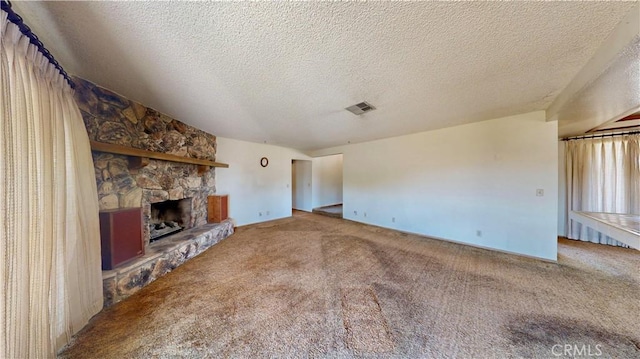 20061 Seneca Rd, Apple Valley, CA 92307 - unfurnished living room featuring carpet floors, a stone fireplace, and a textured ceiling