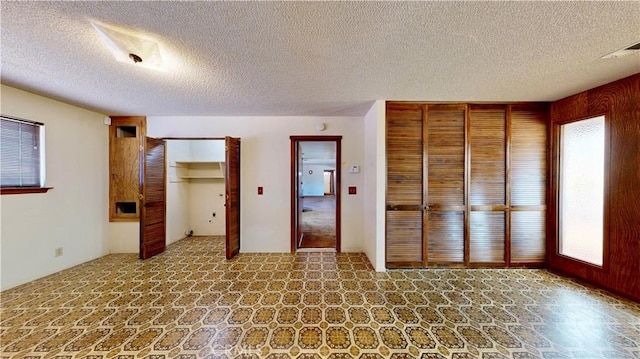 20061 Seneca Rd, Apple Valley, CA 92307 - unfurnished bedroom with multiple closets, a textured ceiling, and stone finish flooring