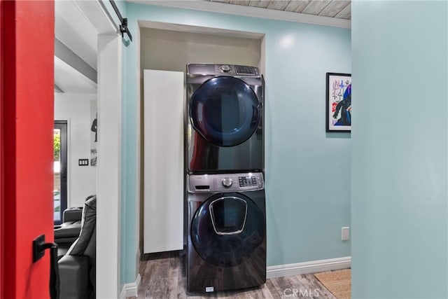 16302 Graystone Ave, Norwalk, CA 90650 - laundry room featuring stacked washer and clothes dryer, baseboards, wood finished floors, and a barn door