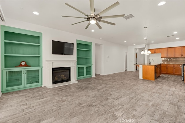 1536 Williamson, Beaumont, CA 92223 - unfurnished living room featuring built in shelves, ceiling fan, light wood-style floors, a glass covered fireplace, and recessed lighting