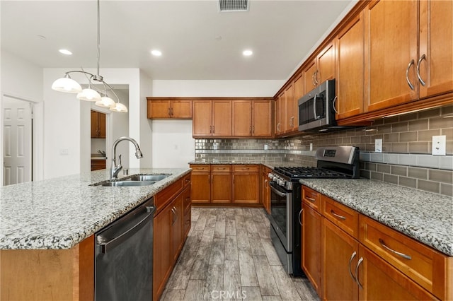 1536 Williamson, Beaumont, CA 92223 - kitchen featuring stainless steel appliances, a sink, brown cabinets, light wood-type flooring, and light stone counters