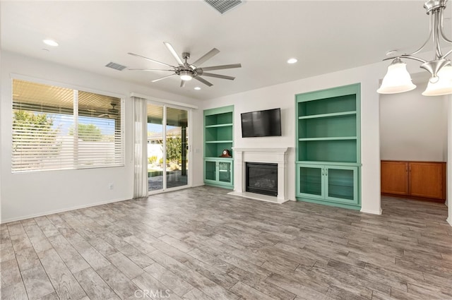 1536 Williamson, Beaumont, CA 92223 - unfurnished living room featuring a ceiling fan, wood finished floors, built in features, a glass covered fireplace, and recessed lighting