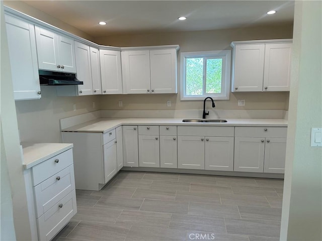 2480 Hall Ave, Jurupa Valley, CA 92509 - kitchen with a sink, under cabinet range hood, recessed lighting, white cabinets, and light countertops