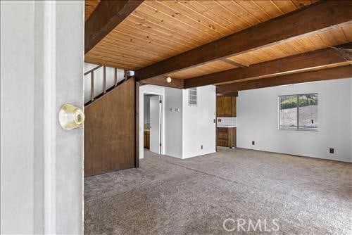 28921 Bear Valley Rd, Tehachapi, CA 93561 - unfurnished living room with wooden ceiling with exposed beams and carpet floors