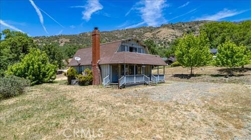 28921 Bear Valley Rd, Tehachapi, CA 93561 - rear view of house featuring a porch and a chimney