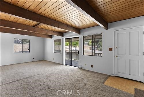 28921 Bear Valley Rd, Tehachapi, CA 93561 - carpeted empty room featuring wooden ceiling with exposed beams and healthy amount of natural light