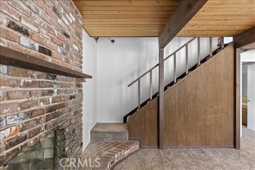 28921 Bear Valley Rd, Tehachapi, CA 93561 - stairway with carpet flooring, wooden ceiling, and brick wall