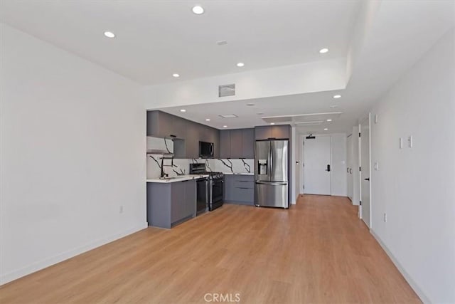 321 S Oxford Ave Unit 606, Los Angeles, CA 90020 - kitchen with stainless steel fridge with ice dispenser, black gas stove, light countertops, light wood finished floors, and recessed lighting