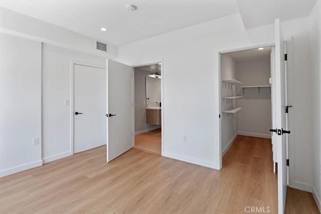 321 S Oxford Ave Unit 606, Los Angeles, CA 90020 - unfurnished bedroom featuring light wood finished floors, recessed lighting, a closet, baseboards, and ensuite bathroom