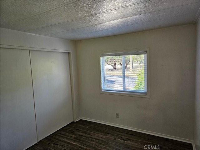 2890 7th St, Clearlake, CA 95422 - unfurnished bedroom with dark wood-style floors, a closet, and baseboards