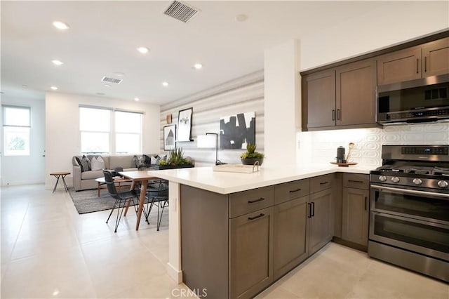 2317 W Broadway, Anaheim, CA 92804 - kitchen with appliances with stainless steel finishes, backsplash, light countertops, recessed lighting, and a peninsula
