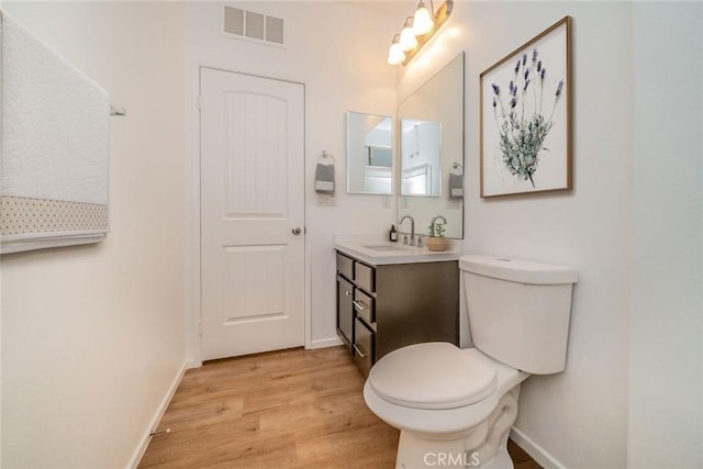 1060 Fortuna St, Perris, CA 92571 - bathroom with wood finished floors, toilet, vanity, and baseboards
