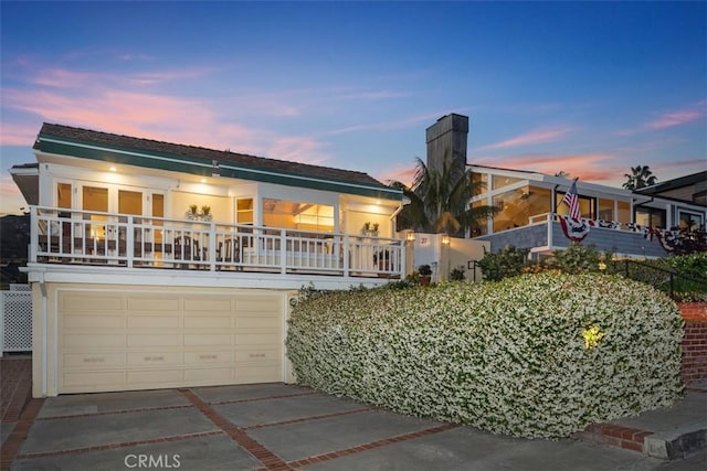 27 S La Senda Dr, Laguna Beach, CA 92651 - view of front facade with concrete driveway, a garage, a balcony, and stucco siding