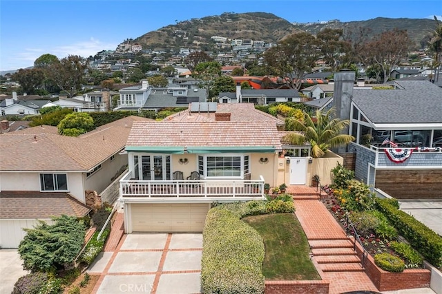 27 S La Senda Dr, Laguna Beach, CA 92651 - view of front of home with stucco siding, a mountain view, driveway, a residential view, and a garage
