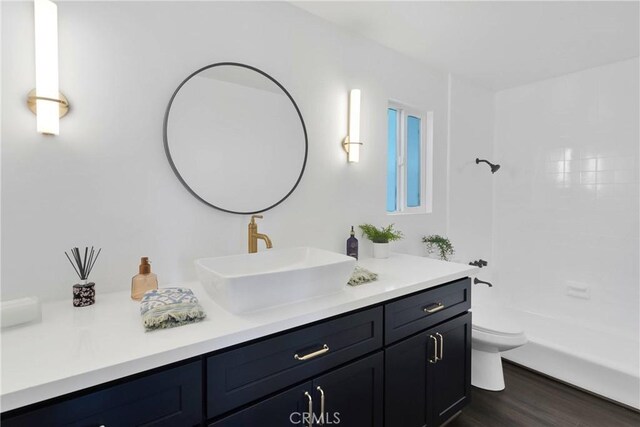 28720 Zion Dr, Lake Arrowhead, CA 92352 - bathroom featuring vanity, toilet, wood finished floors, and washtub / shower combination
