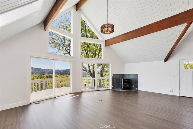 28720 Zion Dr, Lake Arrowhead, CA 92352 - unfurnished living room featuring high vaulted ceiling, beamed ceiling, wood finished floors, a tile fireplace, and baseboards