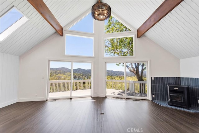 28720 Zion Dr, Lake Arrowhead, CA 92352 - unfurnished living room with wood finished floors, a mountain view, beam ceiling, plenty of natural light, and a skylight