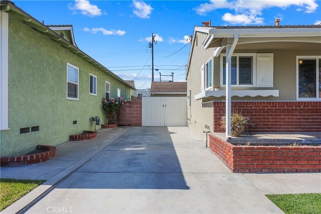 1840 W Southgate Ave, Fullerton, CA 92833 - view of side of home with crawl space, a gate, brick siding, and stucco siding