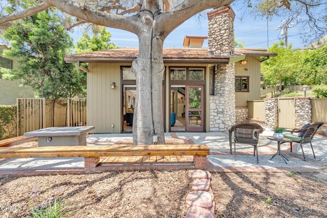 684 Orange Dr, Sierra Madre, CA 91024 - back of property with a chimney, stone siding, and a patio