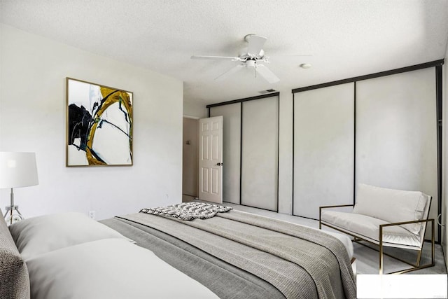 241 Saguaro Pl, Oceanside, CA 92057 - bedroom featuring multiple closets, a ceiling fan, and a textured ceiling