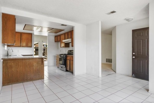 241 Saguaro Pl, Oceanside, CA 92057 - kitchen with stainless steel range with gas cooktop, a sink, brown cabinetry, under cabinet range hood, and a textured ceiling