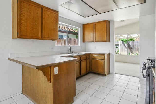 241 Saguaro Pl, Oceanside, CA 92057 - kitchen with brown cabinets, a peninsula, gas stove, and healthy amount of natural light