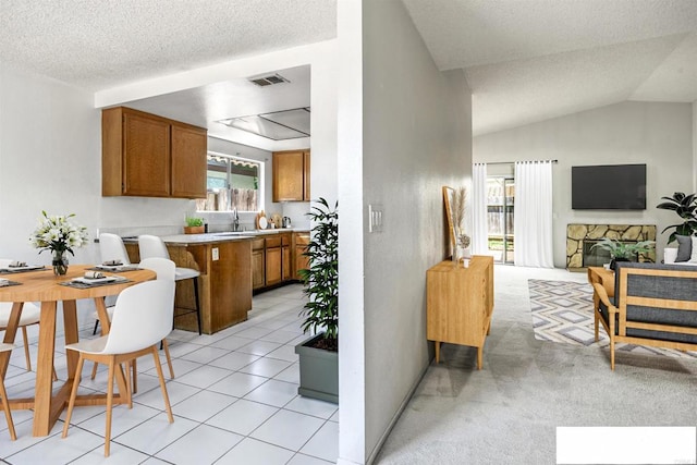 241 Saguaro Pl, Oceanside, CA 92057 - kitchen featuring brown cabinets, light countertops, a peninsula, a textured ceiling, and open floor plan