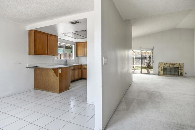 241 Saguaro Pl, Oceanside, CA 92057 - kitchen with brown cabinets, a peninsula, a textured ceiling, a breakfast bar area, and open floor plan
