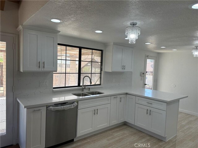 16485 Wintun Rd, Apple Valley, CA 92307 - kitchen with stainless steel dishwasher, a sink, a chandelier, a textured ceiling, and light countertops