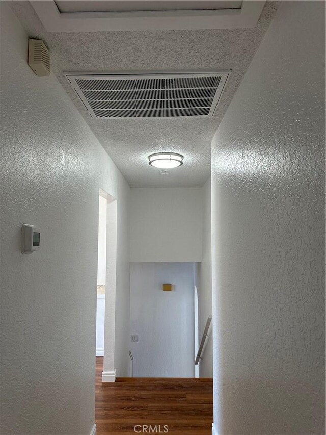 16485 Wintun Rd, Apple Valley, CA 92307 - corridor featuring a textured wall, wood finished floors, an upstairs landing, and baseboards
