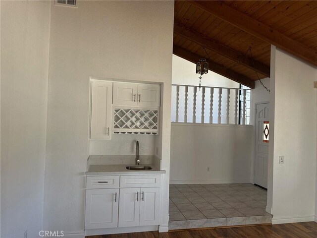 16485 Wintun Rd, Apple Valley, CA 92307 - kitchen with a sink, wood ceiling with exposed beams, white cabinets, light countertops, and baseboards