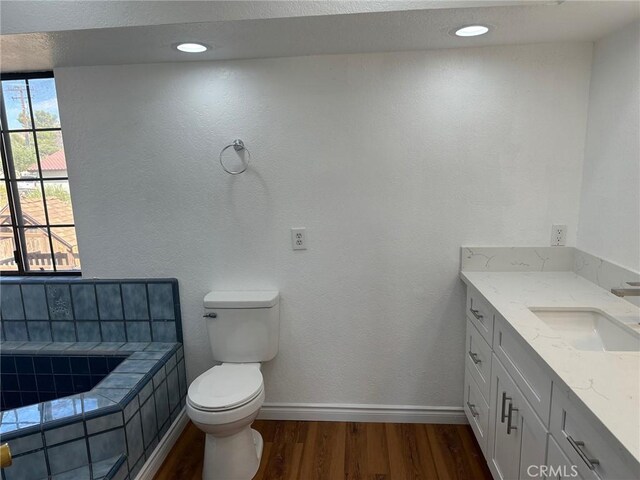 16485 Wintun Rd, Apple Valley, CA 92307 - bathroom with wood finished floors, toilet, vanity, tiled bath, and baseboards