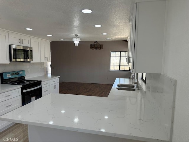 16485 Wintun Rd, Apple Valley, CA 92307 - kitchen with stainless steel microwave, range with electric stovetop, a sink, a textured ceiling, and wood finished floors