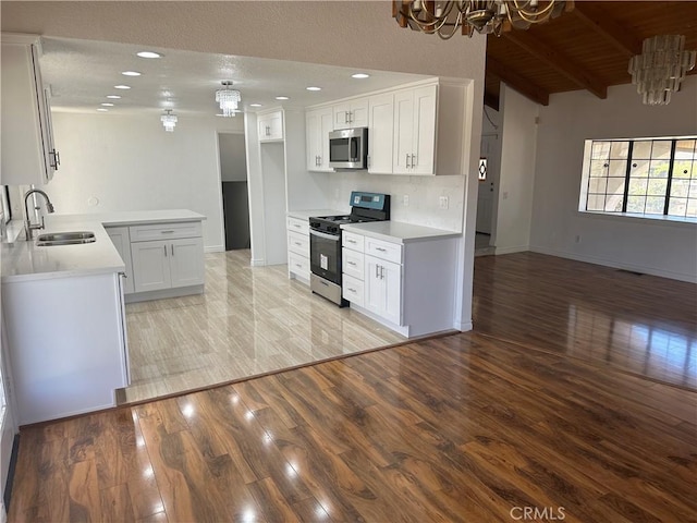 16485 Wintun Rd, Apple Valley, CA 92307 - kitchen featuring appliances with stainless steel finishes, a sink, a chandelier, light wood finished floors, and baseboards